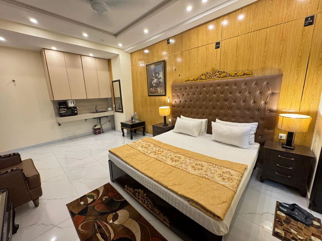 Executive room with a wood-panelled wall, upholstered bed and warm bedside lighting